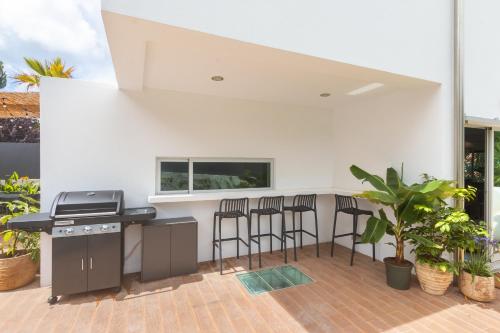 a patio with a grill and bar stools at Beach Villa - 16min to Downtown - 30 PPL in Paço de Arcos