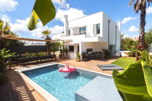 a pool in front of a house with a pink inflatablelatable pool in front at Beach Villa - 16min to Downtown - 30 PPL in Paço de Arcos