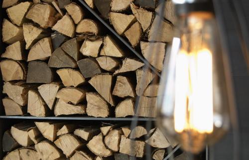a pile of wood next to a wall with a candle at Hotel Boutique Puig Francó - Adults Only in Camprodon