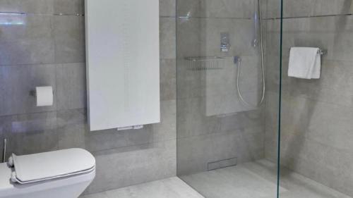 a bathroom with a glass shower with a toilet at Apartamenty Sun & Snow Rezydencja Kapitańska in Kołobrzeg