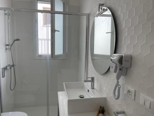 a white bathroom with a sink and a mirror at Mimi Leuca B&b in Leuca