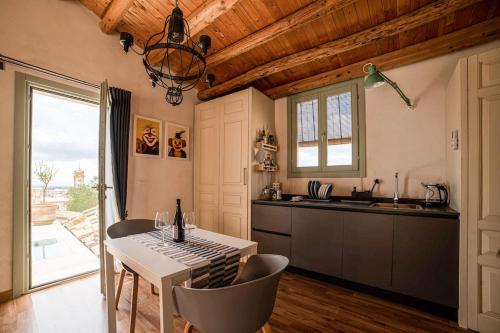 eine Küche mit einem Tisch und Stühlen sowie eine Küche mit einem Fenster in der Unterkunft Scala 70° Attico Esclusivo in Caltagirone