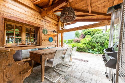 une terrasse en bois avec une table et des chaises en bois dans l'établissement Chalet Victoria - Magnifique chalet avec piscine privée, à Saint-Gervais-les-Bains