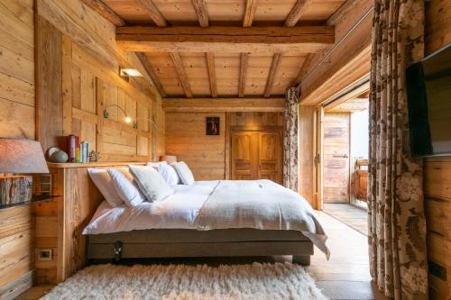 une chambre avec un lit dans une cabane en bois dans l'établissement Chalet Victoria - Magnifique chalet avec piscine privée, à Saint-Gervais-les-Bains