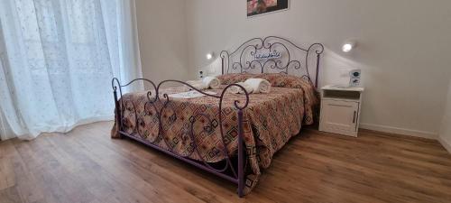 Un dormitorio con una cama de metal con dos gatos. en Norma by Holiday World, en Catania
