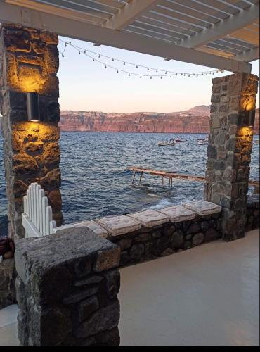 a stone wall with a view of the water at Cave of Love Seafront Sunset View Santorini in Akrotiri