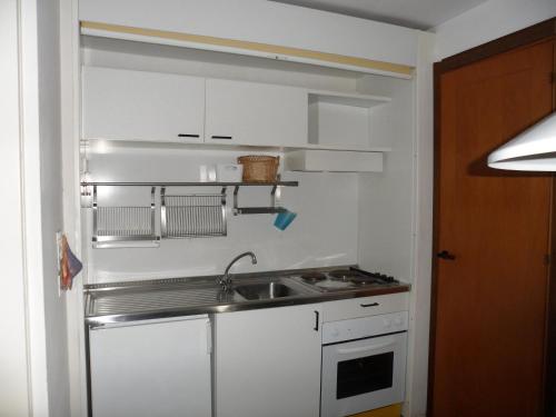 a small kitchen with white cabinets and a sink at Appartamento 109 - Multiproprietà I Boboli BC in Punta Ala