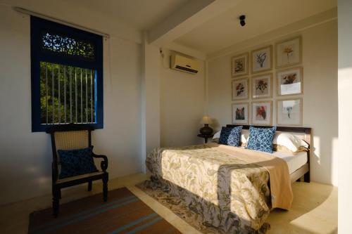 a bedroom with a bed and a window and a chair at Treasure Rock in Kirinda