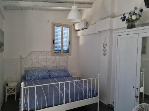 a bedroom with a bed with blue pillows and a window at Villa Sicily Sul Mare Tra Catania e Siracusa in Augusta