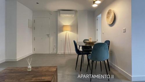 a dining room with a table and blue chairs at Urbanlux Belmonte Suite in Albacete