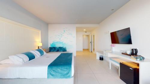 a hotel room with a large bed and a tv at Acrotel Lilyann Boutique Hotel in Elia
