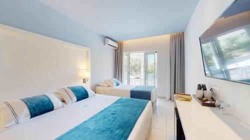 a hotel room with two beds and a window at Acrotel Lilyann Boutique Hotel in Elia