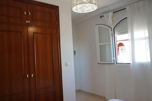 um quarto com uma porta de madeira e um espelho em Hispalis Mazagón Beach 303 em Mazagón