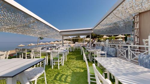 a row of tables and chairs with umbrellas at Acrotel Lilyann Boutique Hotel in Elia