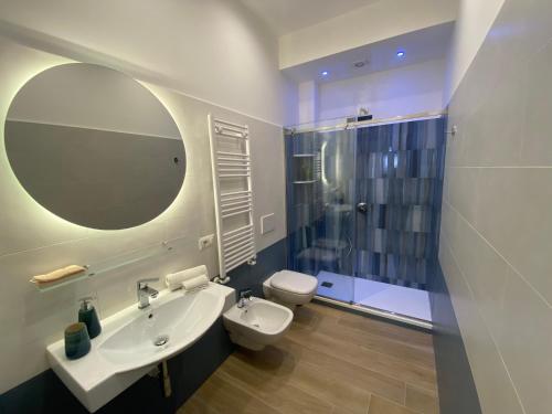 een badkamer met een wastafel, een toilet en een spiegel bij B&B Syrentum in Sorrento