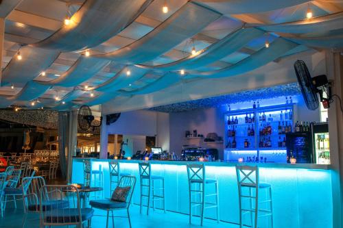 a blue bar with chairs and tables in a restaurant at Acrotel Lilyann Boutique Hotel in Elia