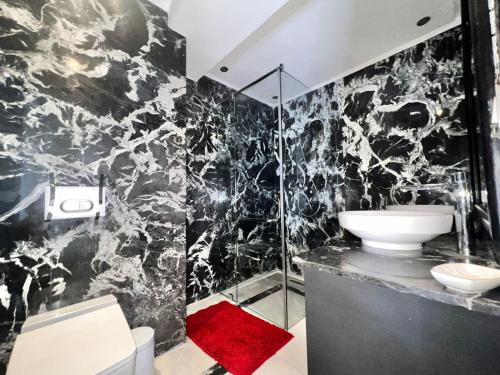 a black and white bathroom with a sink and a shower at Majorelle Splendide Appartement in Marrakech