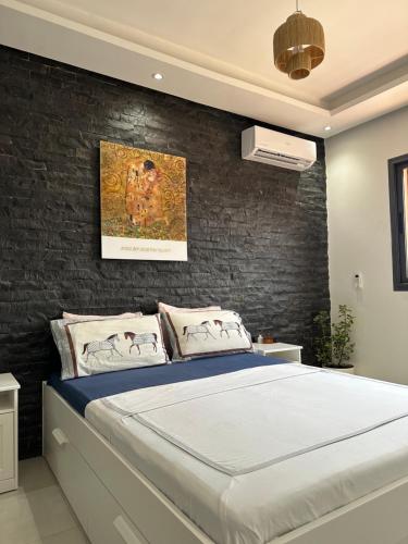 - une chambre avec un lit et un mur en briques dans l'établissement Majorelle Splendide Appartement, à Marrakech
