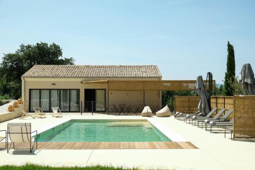 a swimming pool with chairs and a house at Garenne in Livron-sur-Drôme