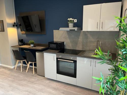 a kitchen with white cabinets and a black counter top at Liro Hotel Viersen in Viersen