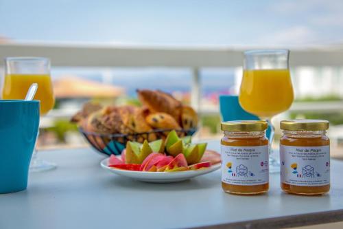 a table with two jars of honey and a bowl of fruit at Best Western Plus La Marina in Saint-Raphaël