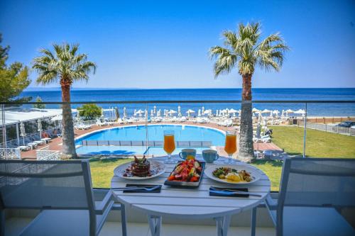 a table with food and a view of the ocean at Acrotel Lilyann Boutique Hotel in Elia
