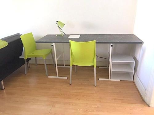 - un bureau avec 2 chaises vertes et une lampe dans l'établissement Lumineux F2 proche GARE TGV, à Mulhouse