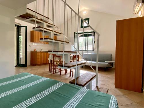 una stanza con un letto e una cucina con una scala a chiocciola di Villetta San Matteo a Mattinata