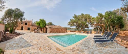 a swimming pool with chairs and a house at Ses cases noves Llucmajor in Llucmajor