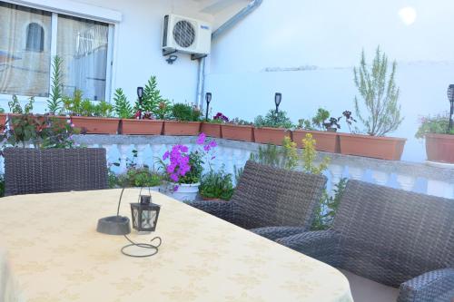a table and chairs on a patio with plants at Guest House Vera in Ulcinj