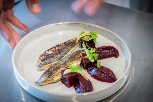 a plate of food with fish and beets on a table at Mercure La Rochelle Vieux Port in La Rochelle