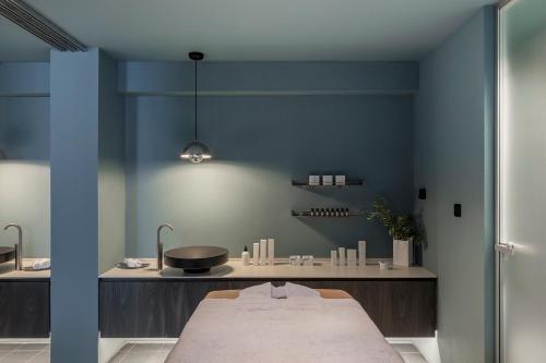 a room with a bed and a blue wall at ANEMI Folegandros in Karavostasi