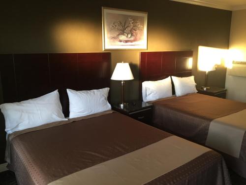 2 camas en una habitación de hotel con 2 lámparas en Seaside Motel en Redondo Beach