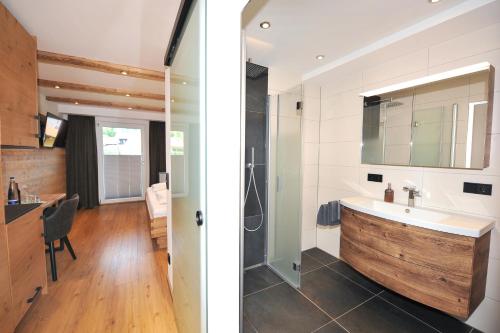 een badkamer met een wastafel en een douche. bij Gasthof - Pension zur Post in Achslach