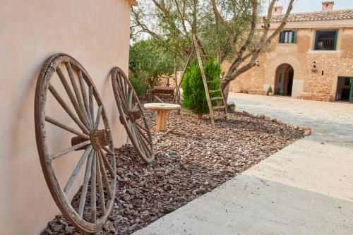 a large wooden wheel leaning against a wall at Ses cases noves Llucmajor in Llucmajor