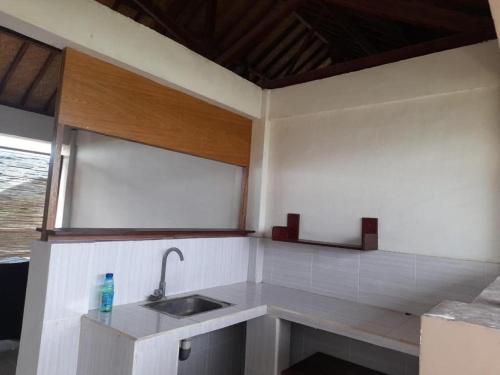 cocina blanca con fregadero y ventana en Kutabay Homestay, en Kuta Lombok