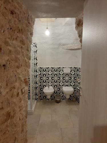 a bathroom with three sinks in a stone wall at Casolare 67 in Noci