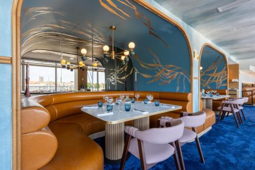 a dining room with a train interior with tables and chairs at Mercure La Rochelle Vieux Port in La Rochelle