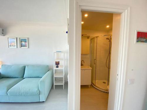 a living room with a blue couch and a bathroom at 06AT1 - Studio cosy bord de mer situation idéale in Antibes