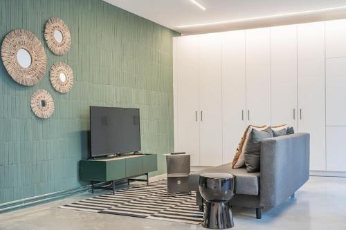 Una sala de estar con un sofá y un televisor de pantalla plana. en Balcon del Centro - BIGLIVING, en Vigo
