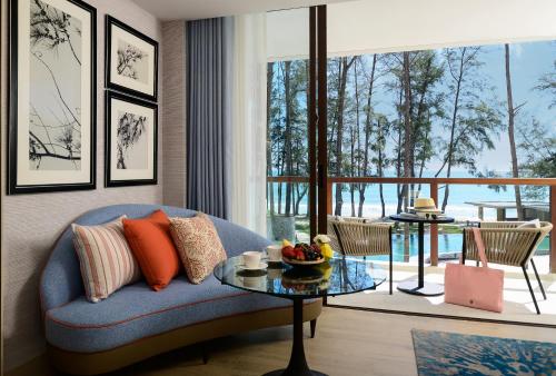 a living room with a blue couch and a table at InterContinental Phuket Resort, an IHG Hotel in Kamala Beach
