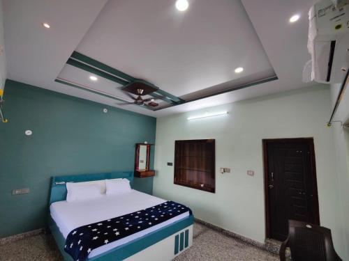 a bedroom with a bed and a blue and white wall at Srinivasa Homestay in Hampi