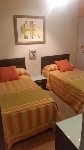 ein Hotelzimmer mit 2 Betten und einem Tisch in der Unterkunft Apartamento Carabuxeira 1 in Sanxenxo