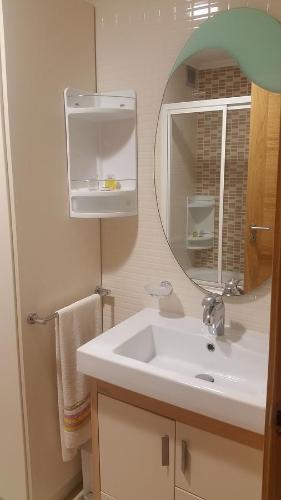 ein Bad mit einem Waschbecken und einem Spiegel in der Unterkunft Apartamento Carabuxeira 1 in Sanxenxo