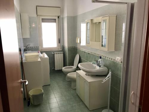 uma casa de banho com um lavatório, um WC e um espelho. em MARE E BICI em Marina di Montenero