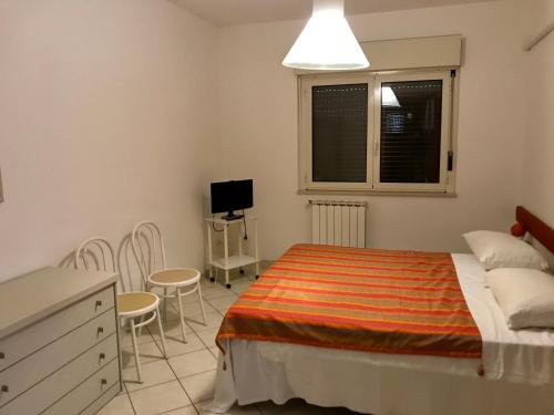 um quarto com uma cama, uma mesa e cadeiras em MARE E BICI em Marina di Montenero