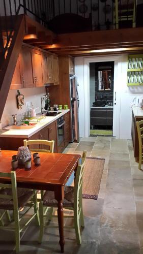 a kitchen with a wooden table and a kitchen with a stove at Xenios Cottages in Lofou