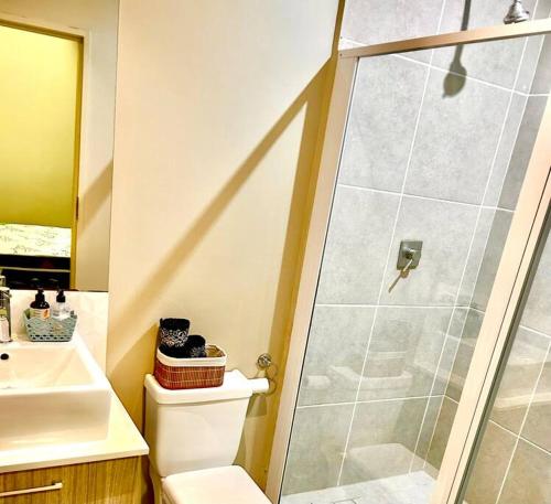 een badkamer met een douche, een toilet en een wastafel bij Neat and cozy apartment in central Rosebank with unlimited Wi-Fi and backup power in Johannesburg