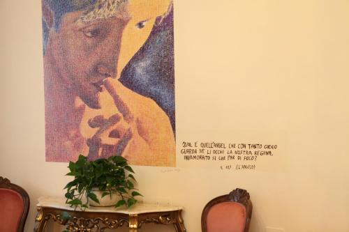 a poster of a woman on a wall next to a table at Hotel Ristorante Ala d'Oro in Lugo