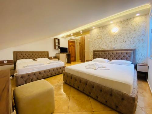 a hotel room with two beds and a television at Apart Hotel Llolla in Ulcinj